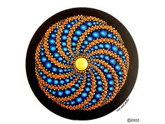 a black plate with an orange and blue design on the front, surrounded by smaller circles