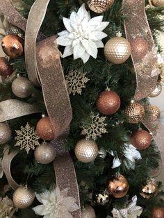 a christmas tree decorated with gold and silver ornaments