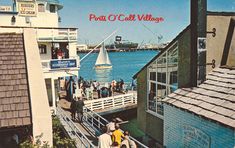 an old postcard shows people walking on the boardwalk near buildings and boats in the water