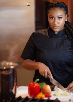 a woman standing in front of a counter cutting food on top of a white plate