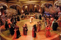 a group of people standing on top of a dance floor in front of chandeliers