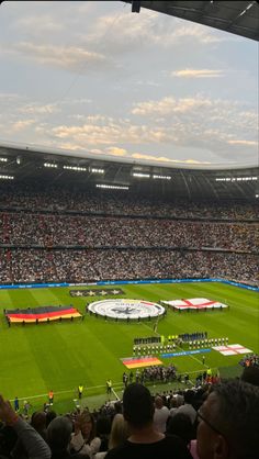 a stadium filled with lots of people watching a soccer game on the field in front of an audience