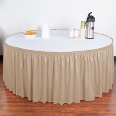 a round table with a red cloth on it and two coffee mugs next to it