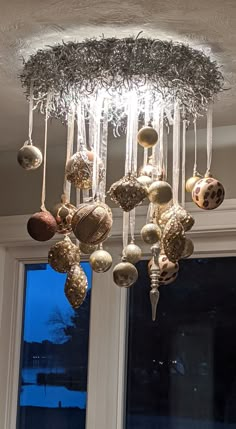 a chandelier with ornaments hanging from it's ceiling in front of a window