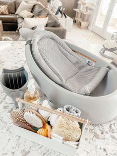 a bathtub with many items in it on the floor next to a couch and coffee table