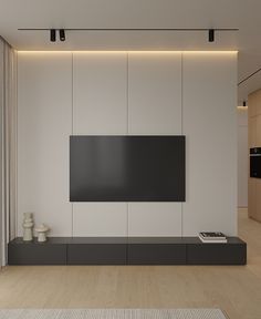 an empty living room with a flat screen tv on the wall