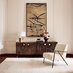 a living room with a large painting on the wall and a chair in front of it