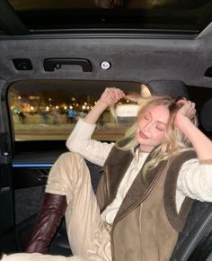 a woman sitting in the back seat of a car