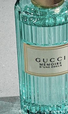 a bottle of gucci memorye is sitting on the floor next to a wall