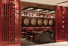 the interior of a restaurant with red walls and wooden partitions to divide it from the dining room