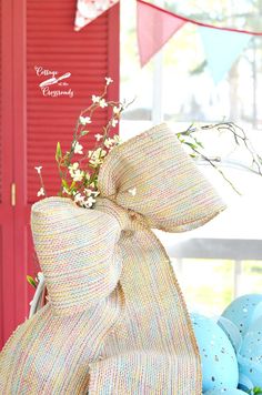 an easter basket with flowers and eggs in front of a red door on a porch