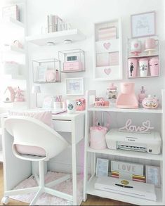 a white desk topped with lots of pink items next to a wall filled with pictures