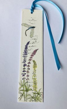 the bookmark is decorated with an image of flowers and plants on it's side