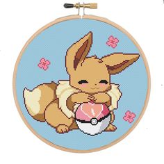 a cross stitch pattern with a small dog holding a ball