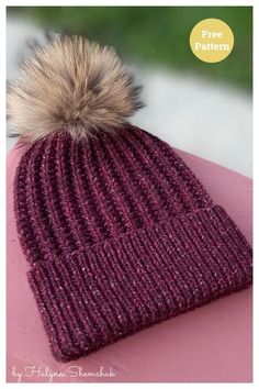 a knitted hat with a pom - pom sitting on top of it