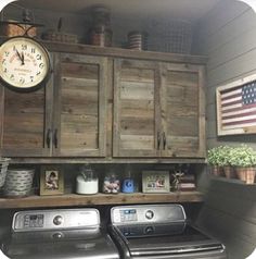 a washer and dryer in a small room with wooden cupboards on the wall