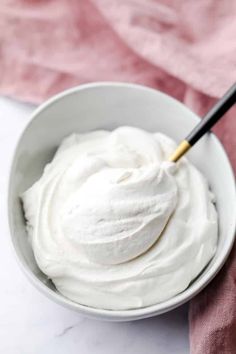 a white bowl filled with whipped cream on top of a pink towel