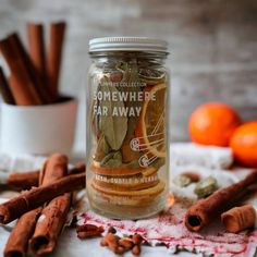 some cinnamons and other spices are on the table next to an empty glass jar