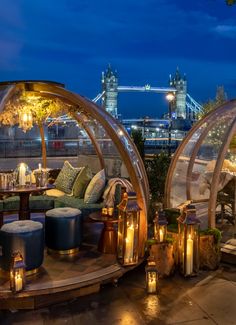 an outdoor living area with two glass domes on the roof and candles lit in front