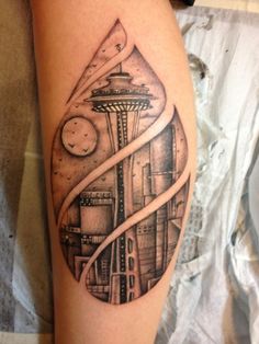 a black and white tattoo on the leg of a person with a clock tower in the background