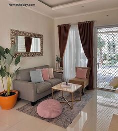 a living room filled with furniture and a large mirror on the wall above it's windows