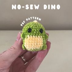 a hand holding a small crocheted toy with the words no sew dino on it