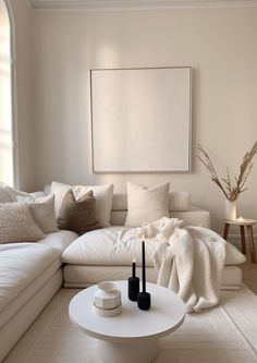 a living room filled with white furniture and pillows