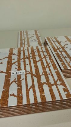 several pieces of paper with brown and white trees on them are sitting on a table