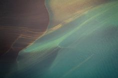 an aerial view of sand dunes and the ocean