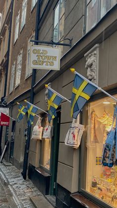 an old town store front with flags hanging from the windows and on the side of the building