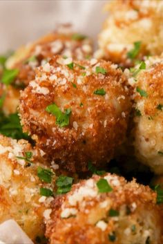 some fried food with parmesan cheese and herbs in a white bowl on a table