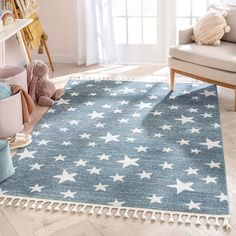 a blue rug with white stars and pom poms on it in a living room