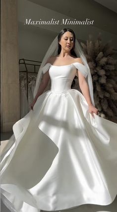 a woman in a white wedding dress posing for the camera