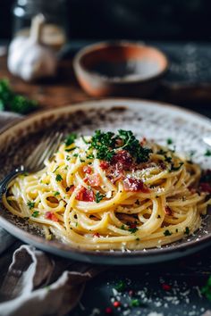 a plate of pasta with parsley on it and a fork in the bowl next to it