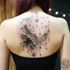 the back of a woman's shoulder with stars and clouds on it