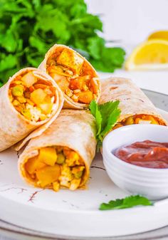 three burritos on a plate with salsa and cilantro in the background