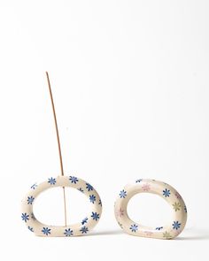 two white and blue flowered ceramic objects sitting side by side on a white surface