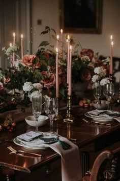 the table is set with flowers and candles