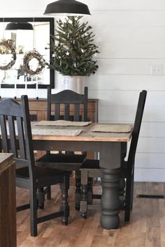 a dining room table with chairs and a christmas tree