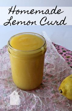 a jar filled with lemon curd sitting on top of a pink table cloth next to a lemon