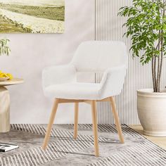 a white chair sitting on top of a rug next to a potted plant