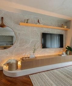 a living room with a large flat screen tv mounted on the wall next to a rug