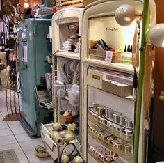 an open refrigerator with food inside of it in a room filled with other items and decorations