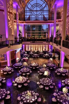 an elegant ballroom with purple lighting and round tables