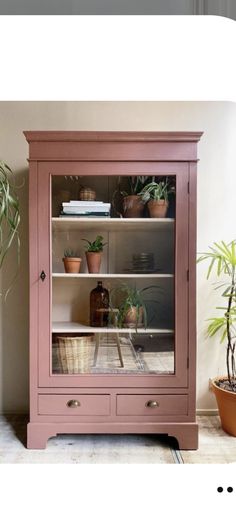 a pink china cabinet with plants in it