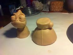 two clay sculptures sitting on top of a table