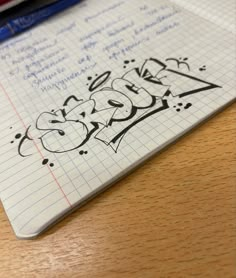 a notepad with writing on it sitting next to a pen and pencils in the background