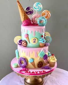 there is a cake decorated with donuts and candy on the top tier, including an ice cream cone