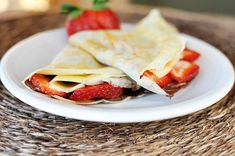 two crepes on a plate with strawberries