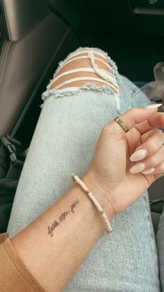 a woman's arm with a small tattoo saying, i love you on it